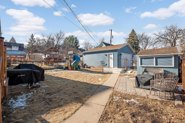 view of yard featuring a garage, an outbuilding, and a playground