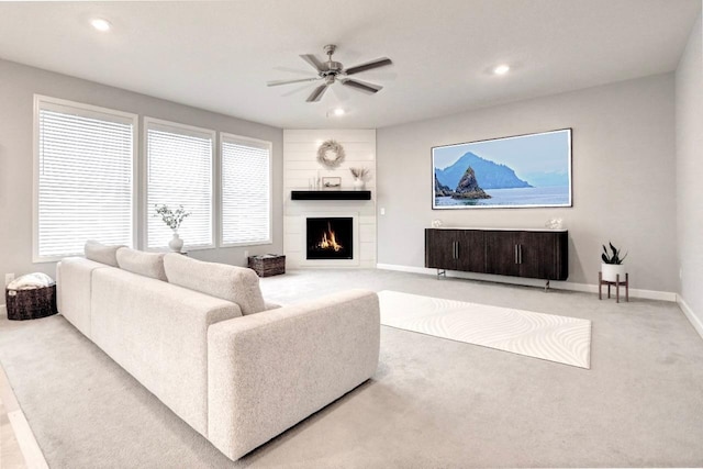 carpeted living room with ceiling fan