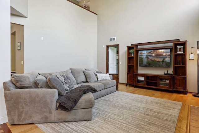 living room featuring a high ceiling and light wood-type flooring