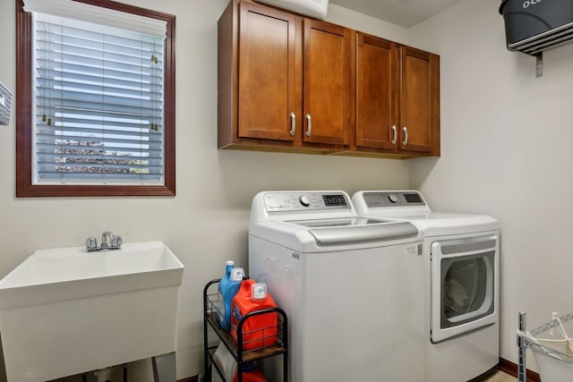 laundry area featuring cabinets, sink, and washer and dryer