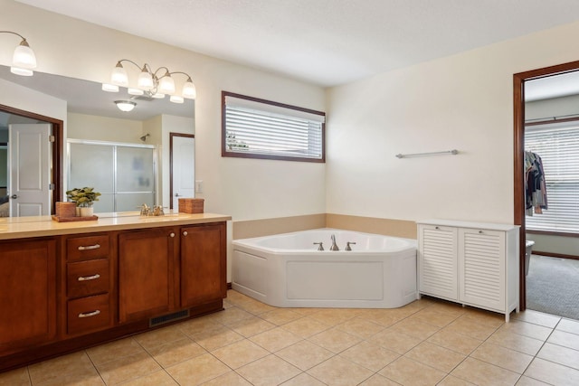 bathroom featuring tile patterned flooring, vanity, and separate shower and tub