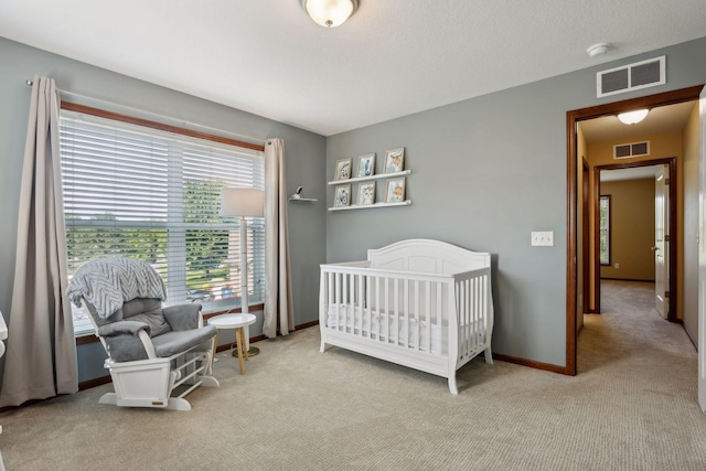 bedroom featuring a crib and light colored carpet