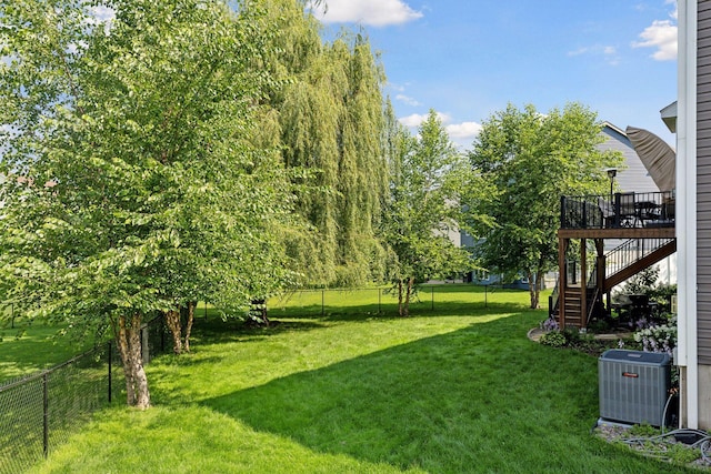 view of yard featuring central AC unit and a wooden deck