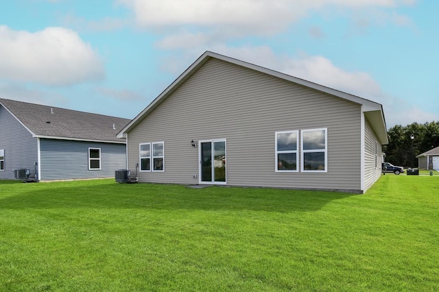 rear view of property featuring central AC unit and a yard