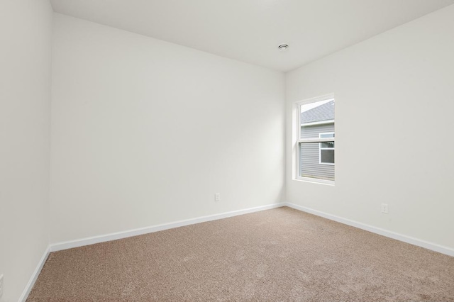 carpeted empty room featuring baseboards