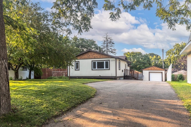 view of front of home featuring an outbuilding, a garage, and a front yard