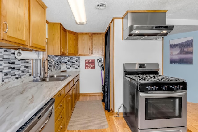 kitchen featuring extractor fan, sink, decorative backsplash, stainless steel appliances, and a textured ceiling