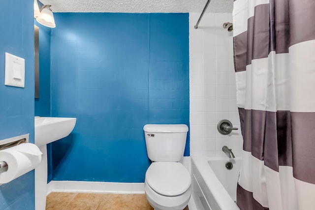 bathroom with shower / tub combo with curtain, toilet, and a textured ceiling