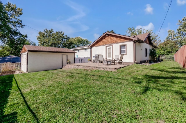 rear view of house with a storage shed, a lawn, and a patio area