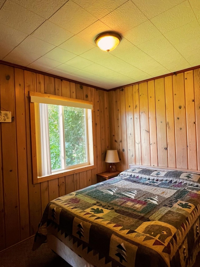 bedroom featuring wooden walls