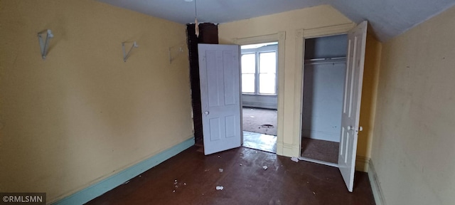 unfurnished bedroom featuring vaulted ceiling and a closet