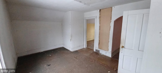 unfurnished bedroom featuring lofted ceiling