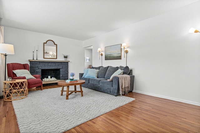 living room featuring wood-type flooring and a fireplace