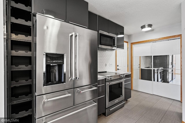 kitchen featuring backsplash, stainless steel appliances, and a textured ceiling