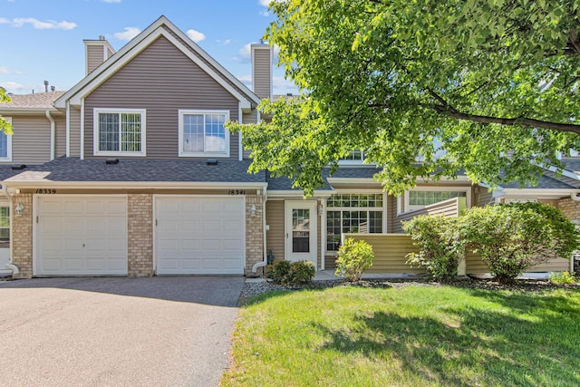 18341 Coneflower Ln, Eden Prairie, MN 55346 - townhome / multi-family property featuring asphalt driveway, a front yard, a garage, and a shingled roof