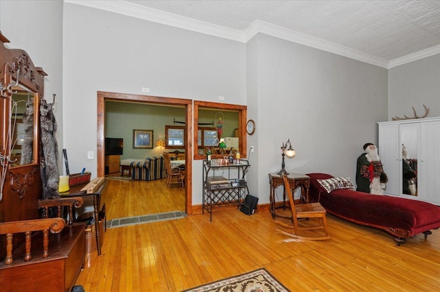 sitting room with crown molding, a textured ceiling, and wood-type flooring