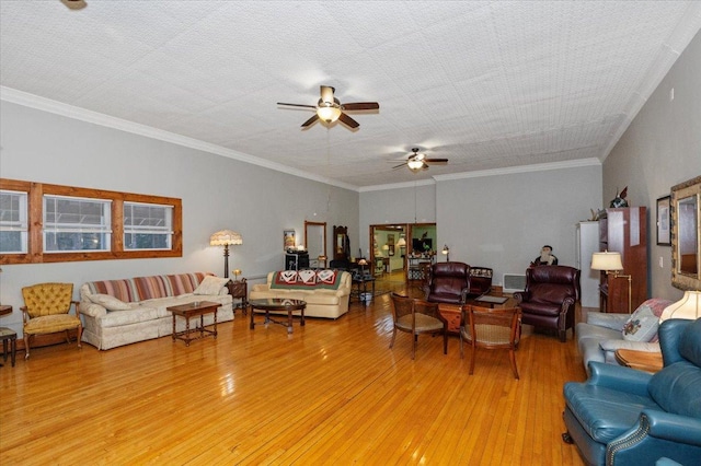 living room with ceiling fan, ornamental molding, light hardwood / wood-style floors, and a textured ceiling