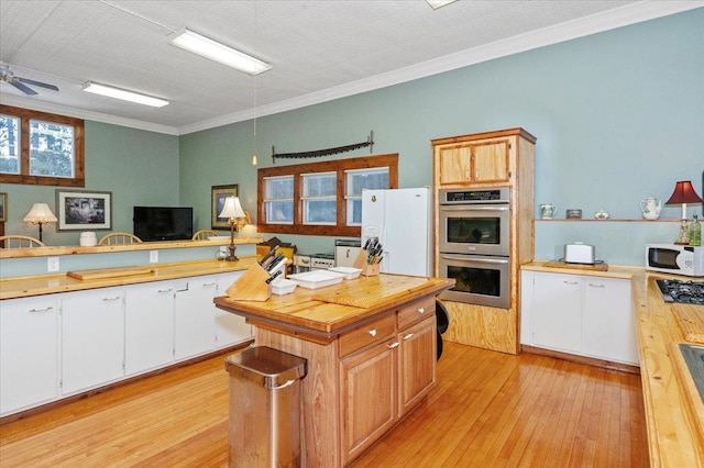 kitchen featuring crown molding, ceiling fan, appliances with stainless steel finishes, white cabinets, and light hardwood / wood-style floors