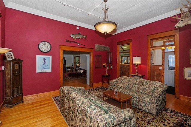 living room featuring light wood-type flooring, a textured ceiling, and ornamental molding