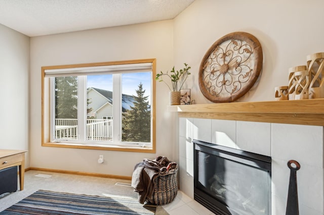 interior details featuring carpet floors, a tile fireplace, and a textured ceiling