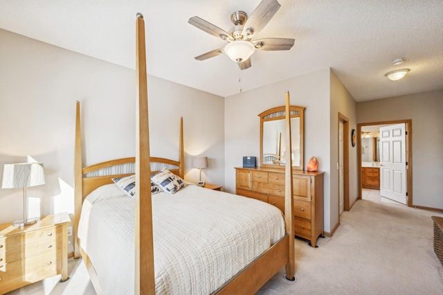 carpeted bedroom featuring ceiling fan, connected bathroom, and a textured ceiling