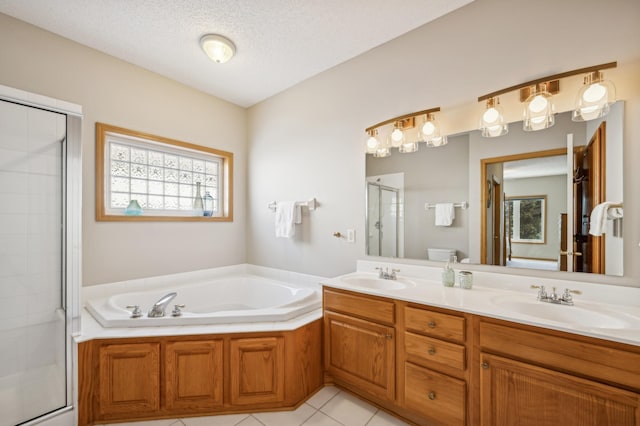 full bathroom with separate shower and tub, vanity, a textured ceiling, tile patterned floors, and toilet