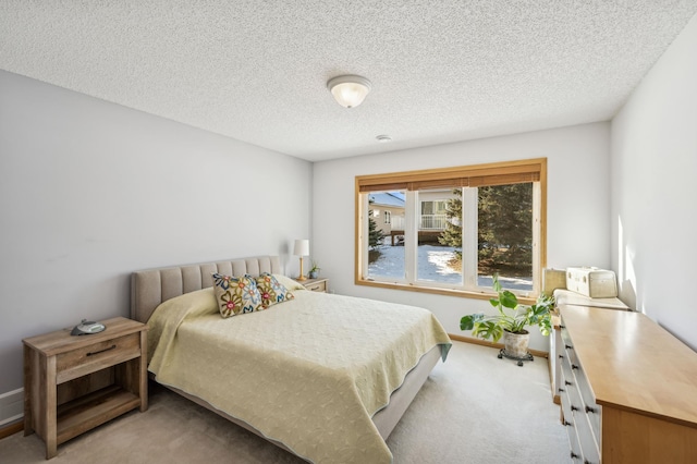 bedroom with light carpet and a textured ceiling