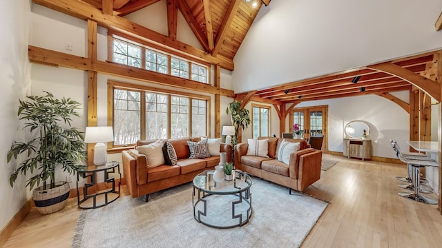 living room with french doors, wood ceiling, high vaulted ceiling, light hardwood / wood-style flooring, and beam ceiling