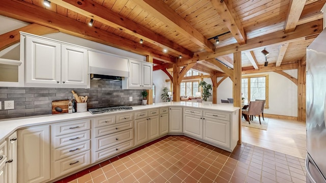 kitchen featuring stainless steel appliances, decorative backsplash, white cabinets, and kitchen peninsula