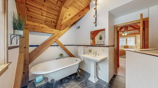 bathroom featuring sink, tile walls, lofted ceiling with beams, a tub to relax in, and wooden ceiling