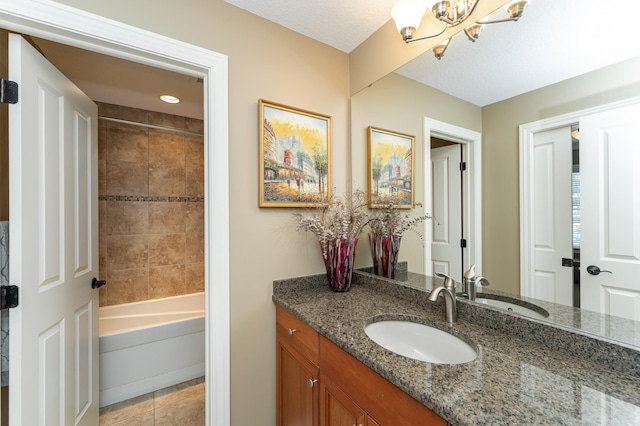 bathroom with tile patterned floors, a textured ceiling, a notable chandelier, and vanity