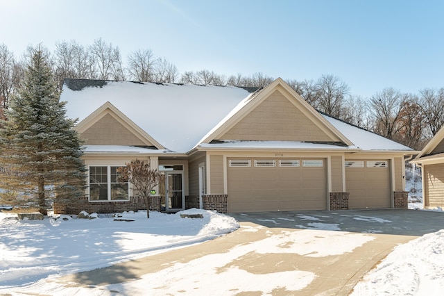 view of front of home featuring a garage, brick siding, and driveway