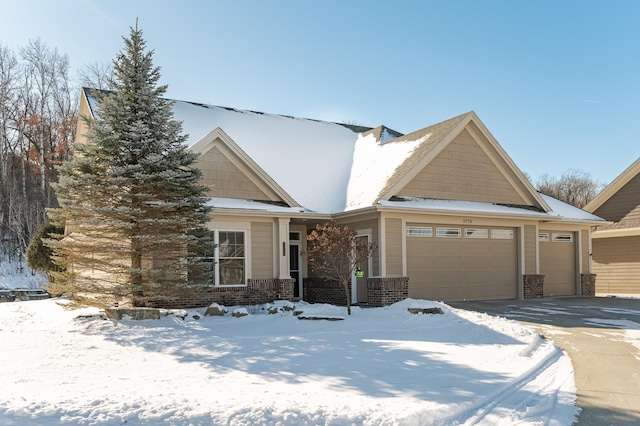 view of front of property featuring a garage, driveway, and brick siding