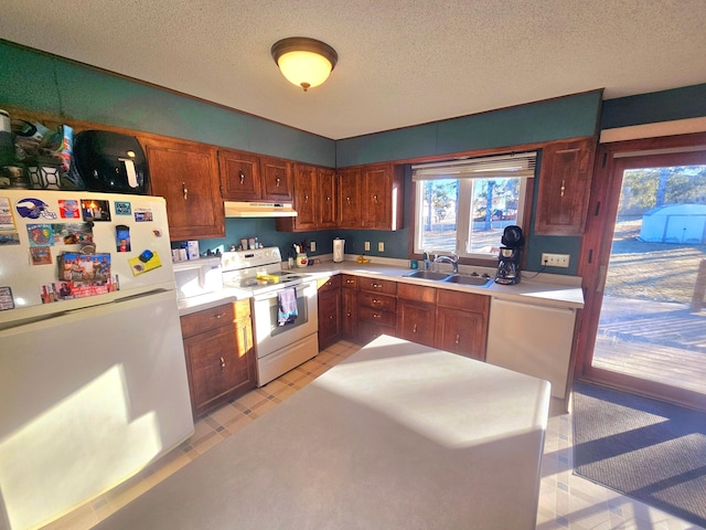 kitchen featuring white appliances, sink, and a textured ceiling