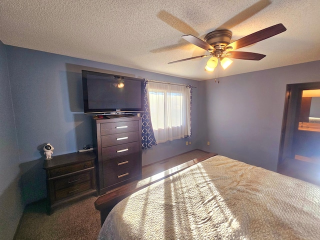 carpeted bedroom featuring ceiling fan and a textured ceiling