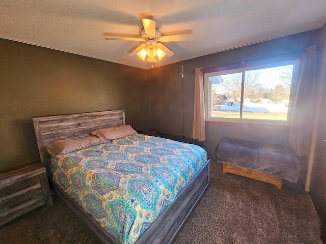 bedroom featuring dark carpet, a textured ceiling, and ceiling fan