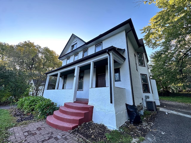 view of front facade featuring cooling unit and covered porch