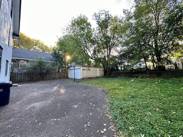 view of yard featuring a garage and an outbuilding