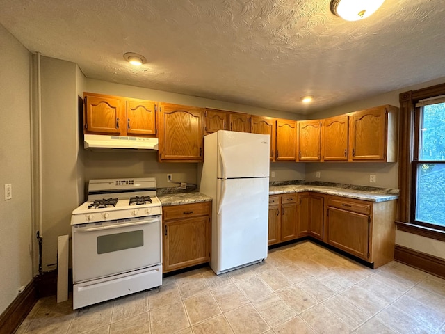 kitchen featuring a textured ceiling and white appliances