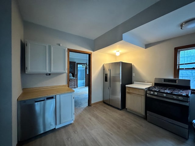 kitchen with white cabinetry, light wood-type flooring, and appliances with stainless steel finishes