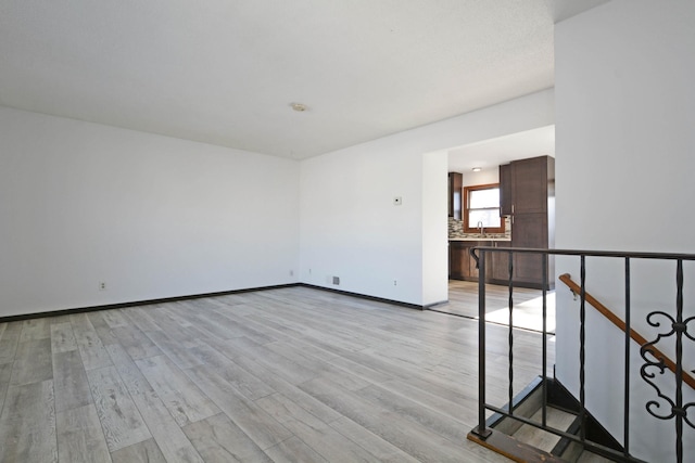 empty room featuring sink and light hardwood / wood-style floors