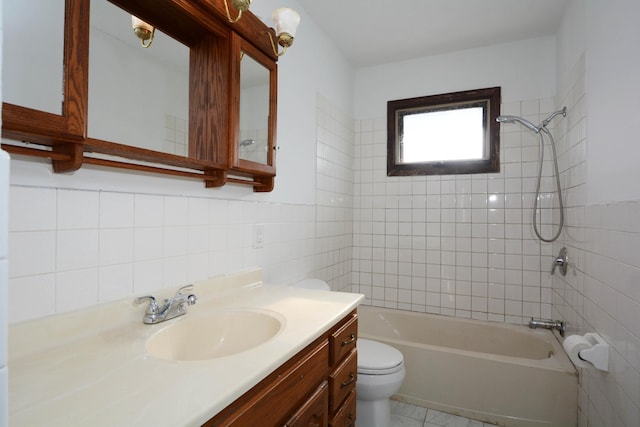 full bathroom featuring tiled shower / bath combo, vanity, tile walls, and toilet