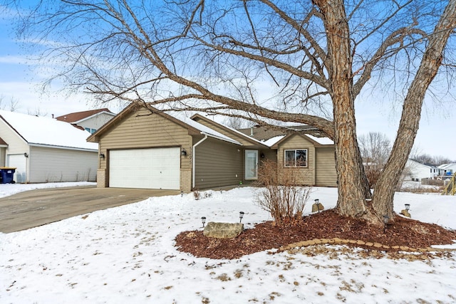 single story home featuring driveway, brick siding, and an attached garage