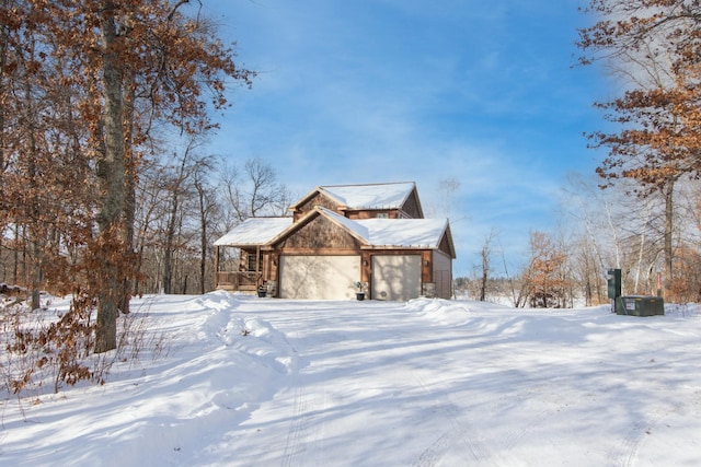 view of snow covered exterior featuring a garage