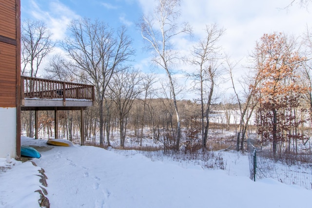 yard covered in snow featuring a wooden deck