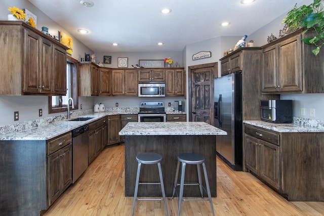 kitchen featuring light hardwood / wood-style flooring, sink, a kitchen island, and appliances with stainless steel finishes