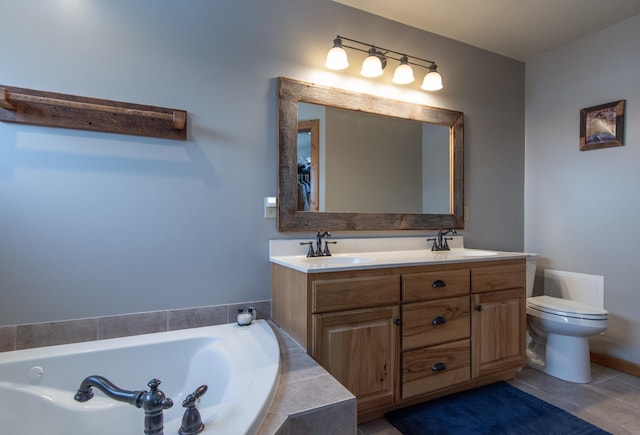 bathroom featuring tiled tub, vanity, tile patterned flooring, and toilet