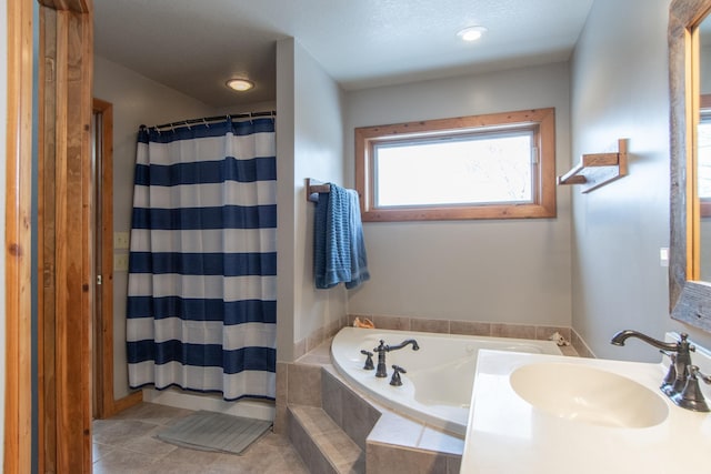 bathroom featuring plus walk in shower, tile patterned flooring, and sink