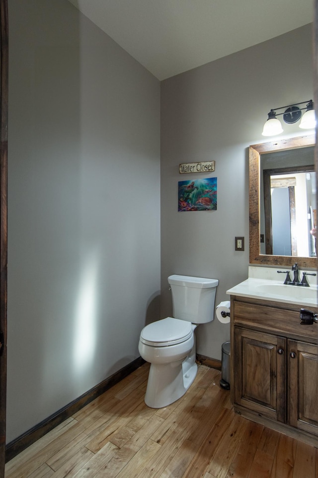 bathroom featuring wood-type flooring, vanity, and toilet