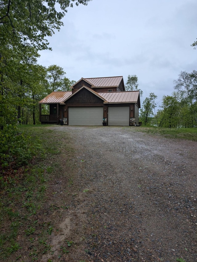 9414 Beverly Dr, Breezy Point, MN 56472 - view of front of property with a standing seam roof, dirt driveway, metal roof, and an attached garage